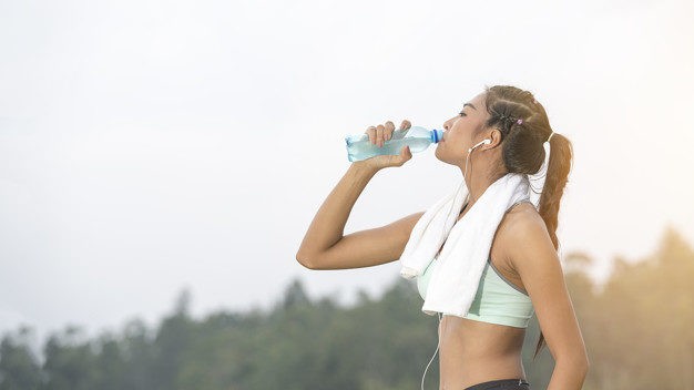 young-asian-woman-thirsty-and-drinking-pure-water-after-jogging